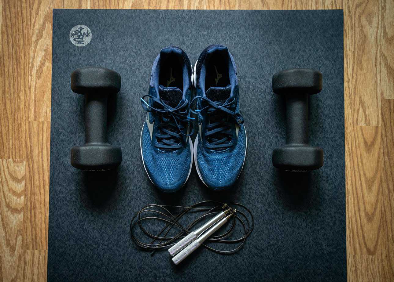 An at-home gym with weights, a mat, and fitness sneakers