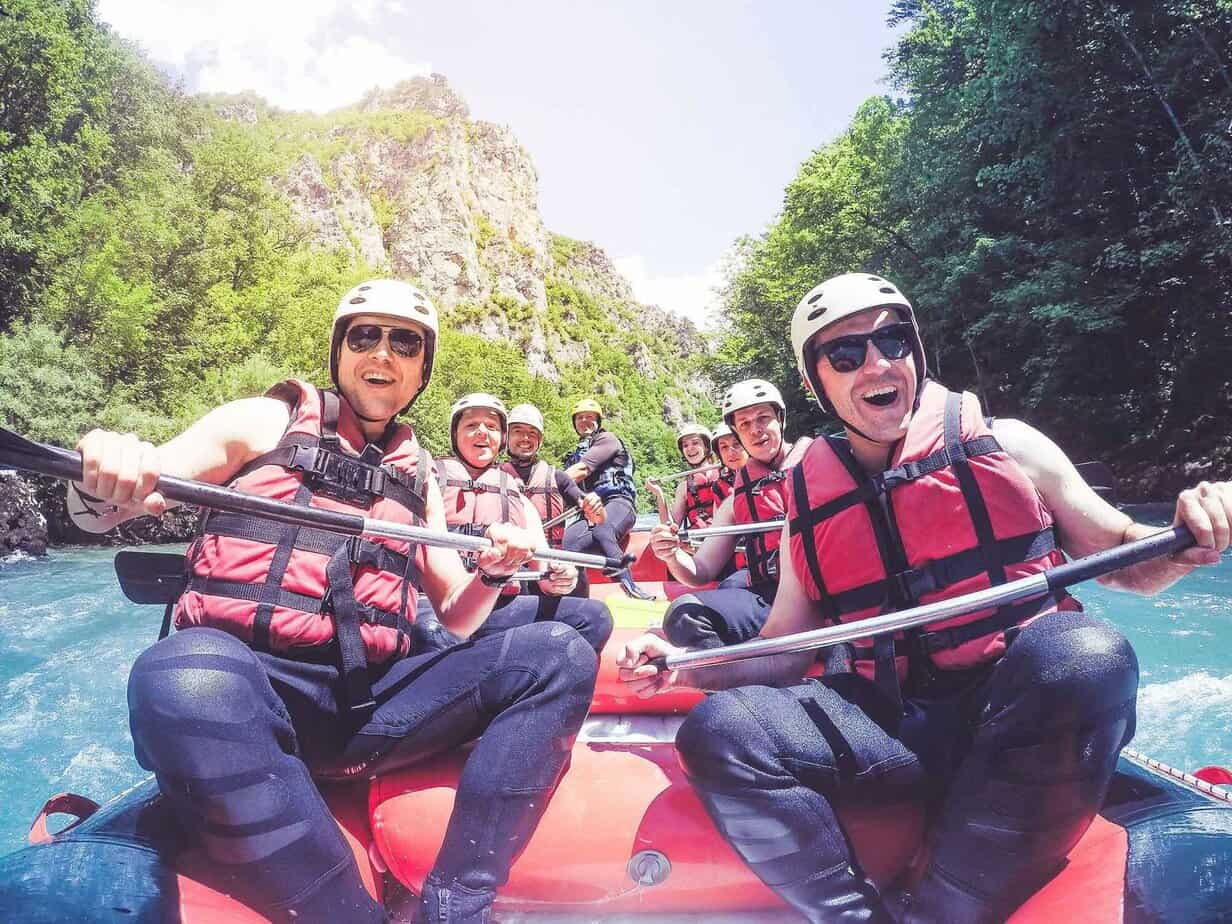 Group of extended care drug rehab clients river rafting as a fun outdoor sover activity.