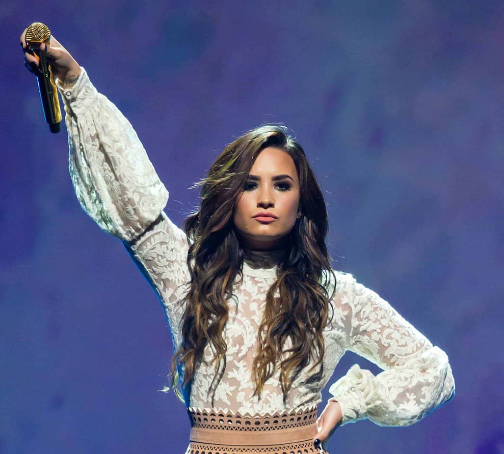 Demi lovato holding microphone posing on stage