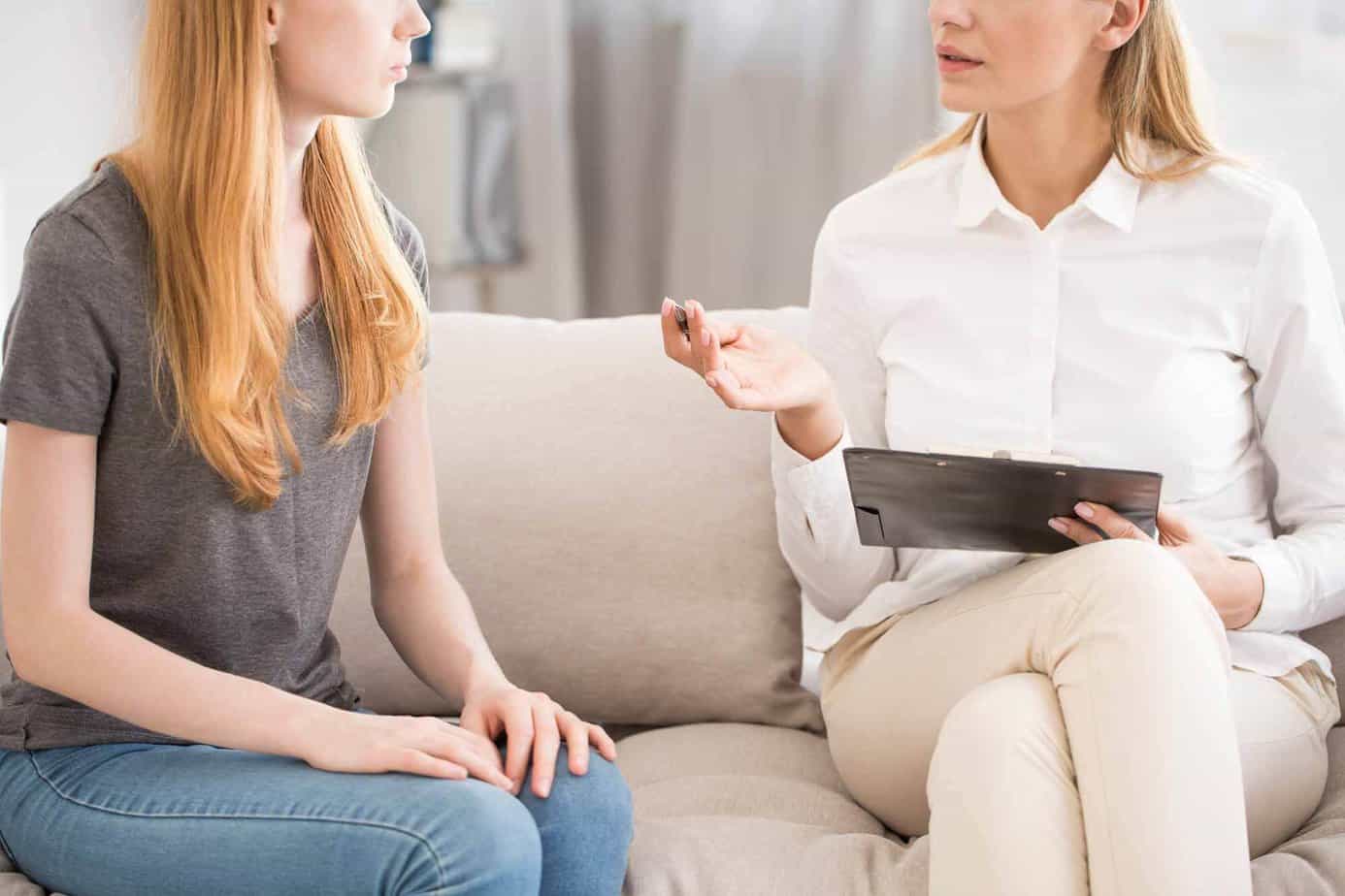 Female clinician meeting with teenage girl for a one on one addiction assessment