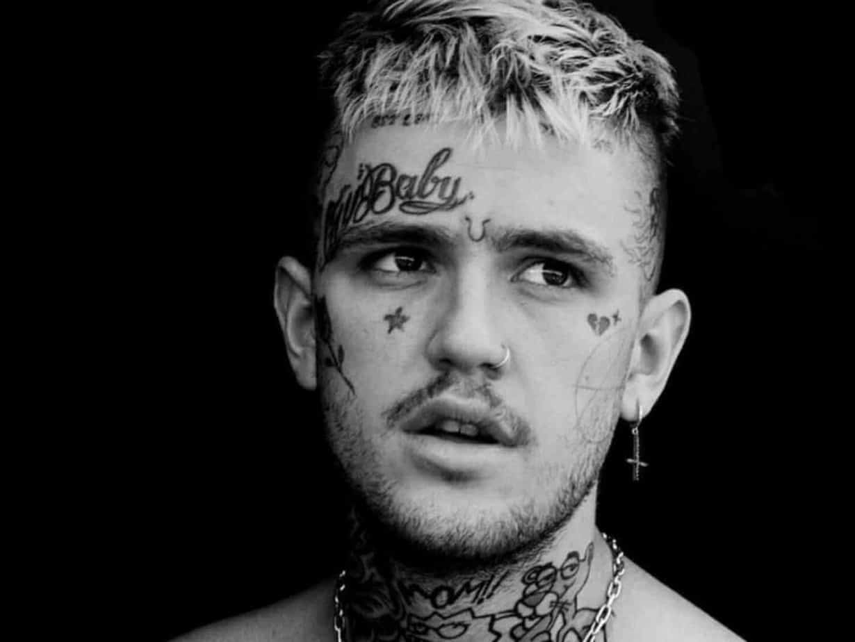 black and white photo of man with face tattoos and earring