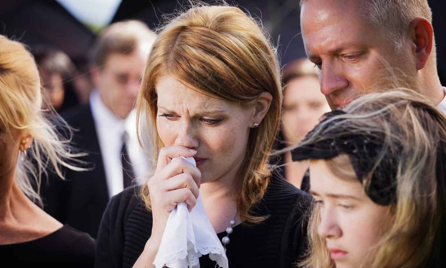 woman at funeral holding a tissue