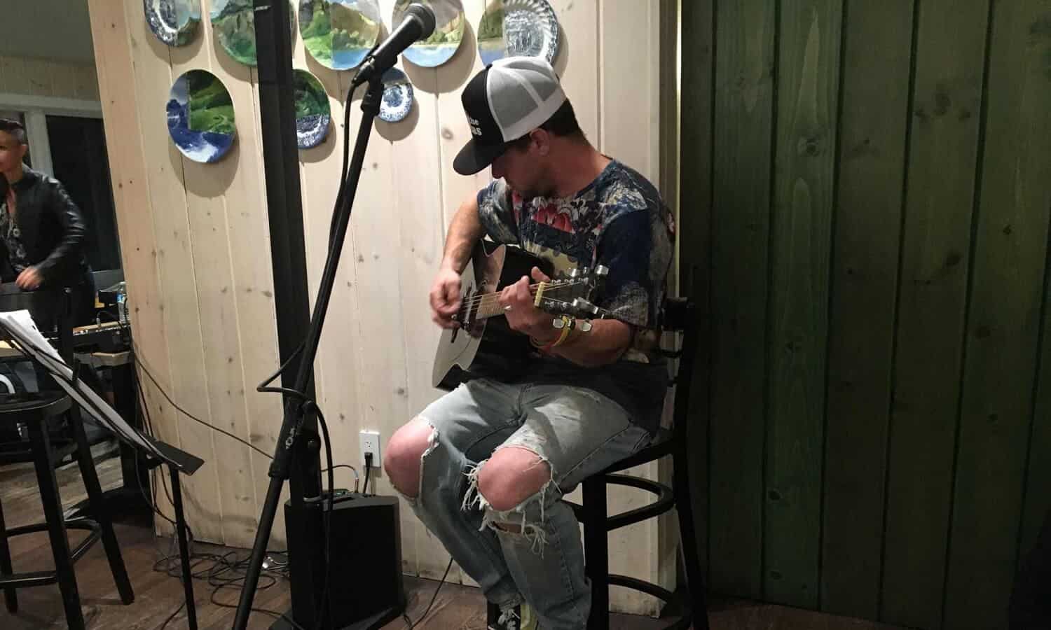 Man playing guitar at Mountainside Treatment Center Alumni Open Mic Night