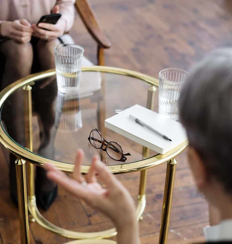 Two women talking with a table between them- Pexels