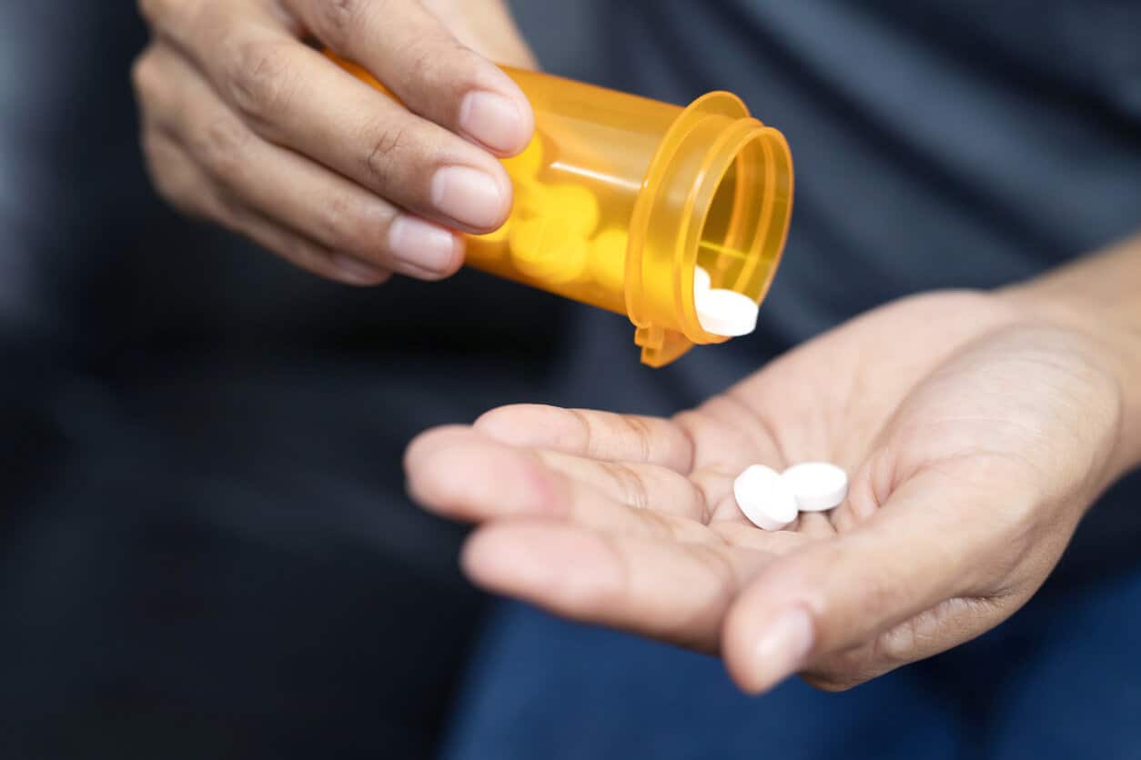 pills in hand. using respectful language is important to reduce stigma surrounding addiction