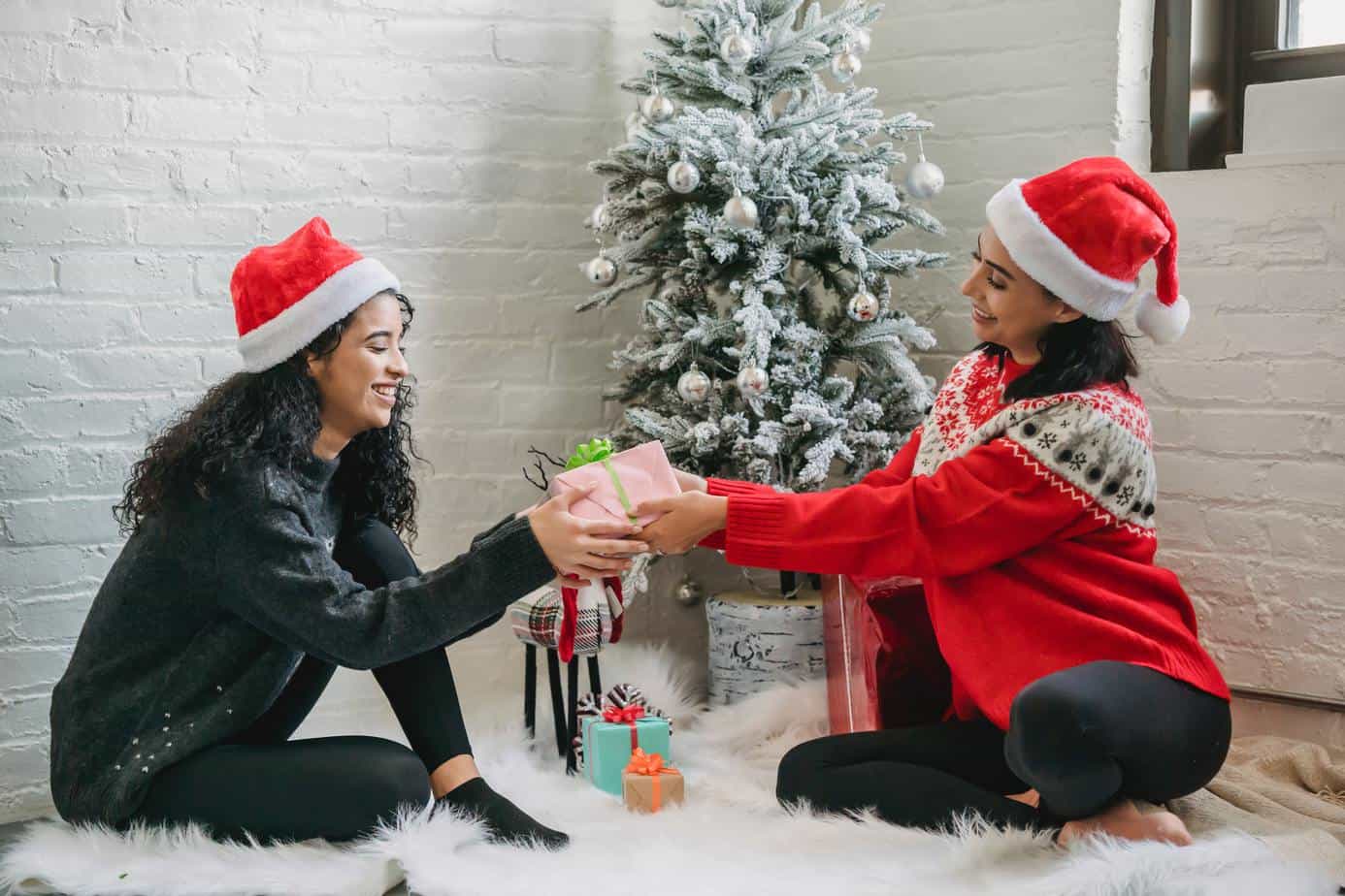 two women exchanging holiday gifts