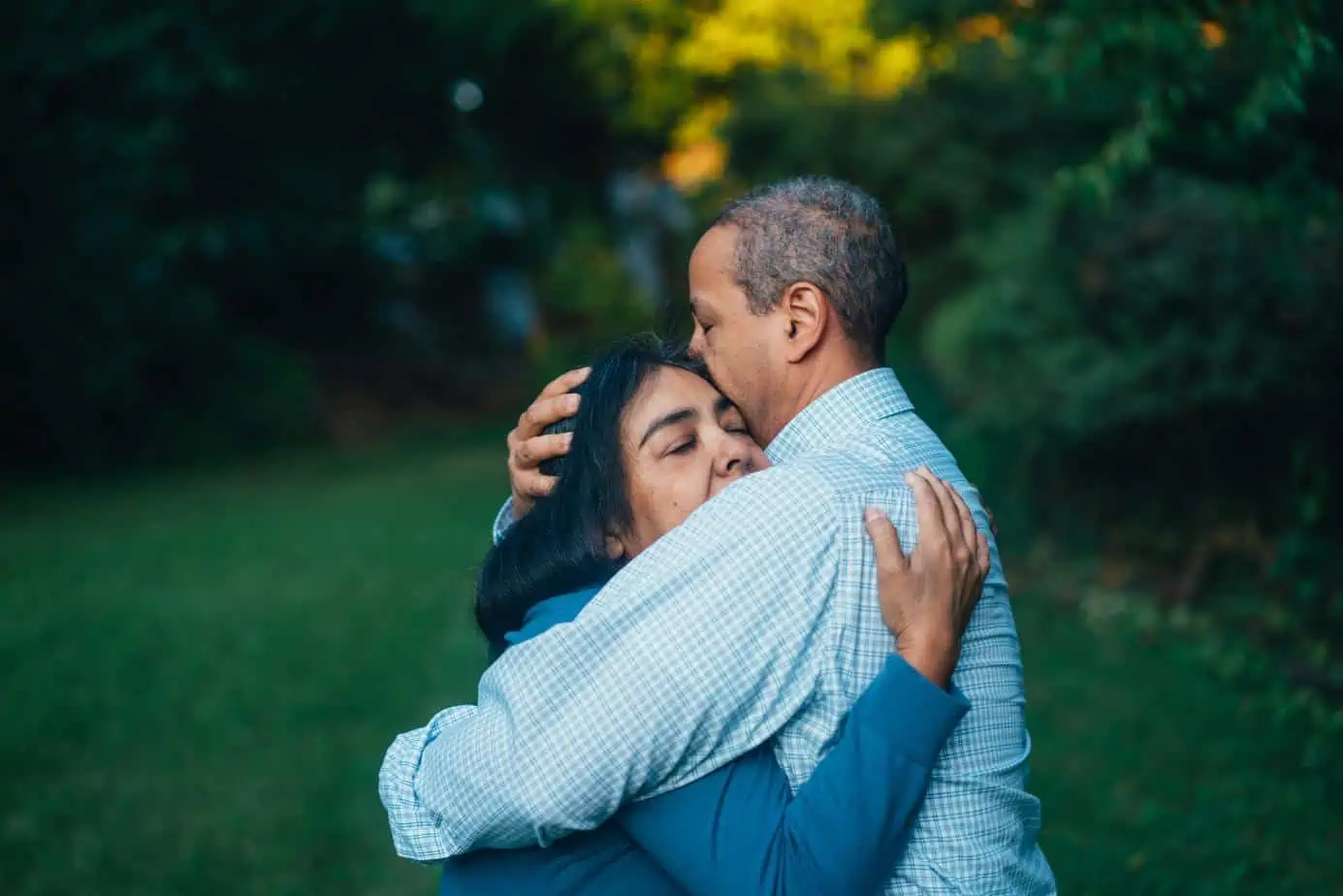 A woman hugs a man while making amends in recovery