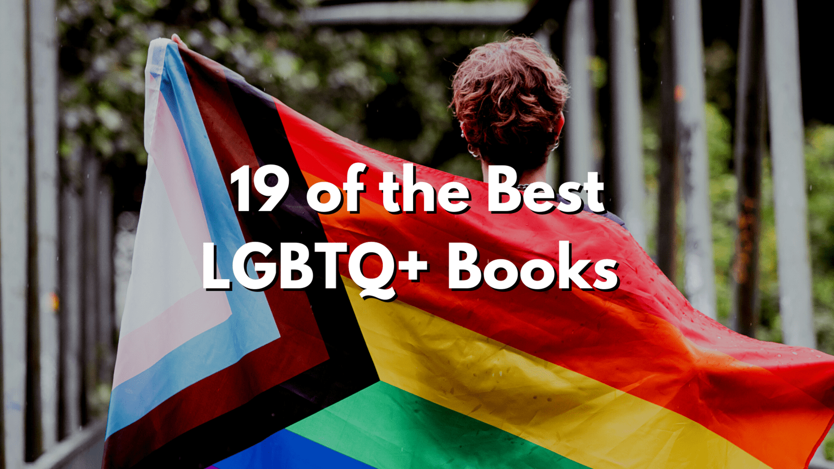 A person with short hair holds up a LGBTQ pride flag behind white text that reads" 19 of the Best LGBTQ+ Books"