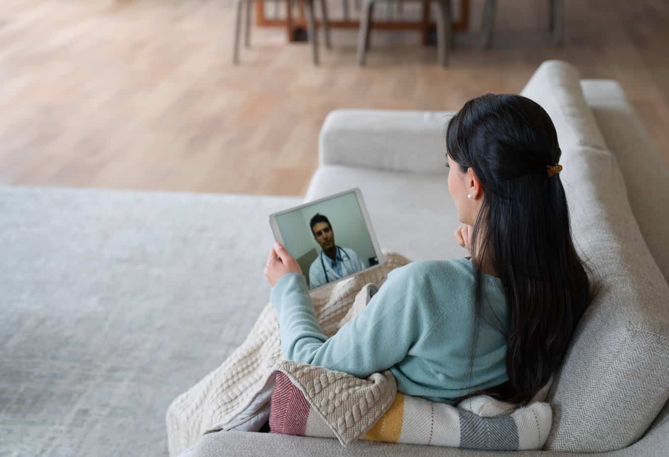 Woman at home feeling poorly and talking to her doctor on a video call