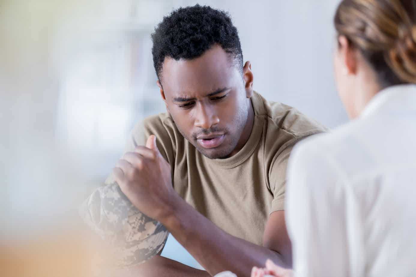 military veteran stares down and looks upset