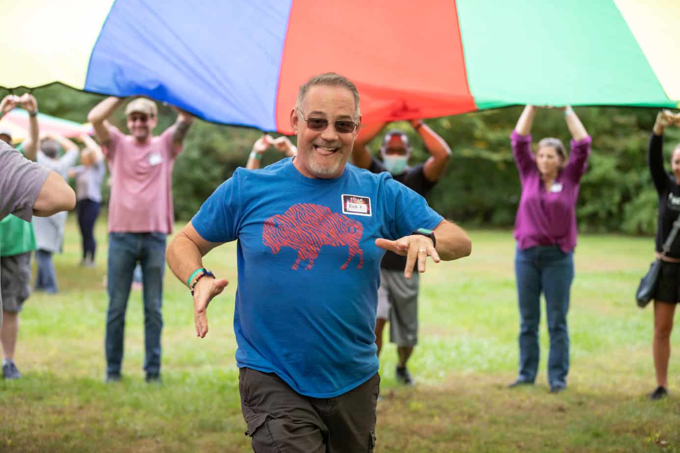 A happy man playing parachute lawn games at Mountainside addiction treatment center in Connecticut.