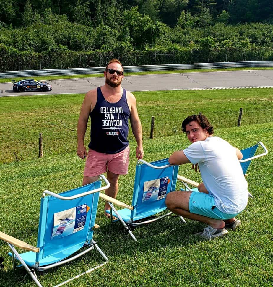 Two men smiling on field by lawn chairs outside at Mountainside Treatment Center Extended Care Lime Rock Park Event Summer 2022