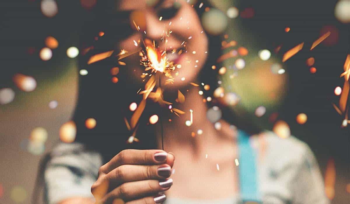 Close up of woman wearing nail polish holding sparkler