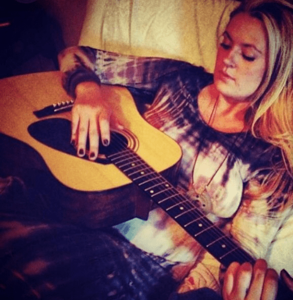 woman playing guitar on couch