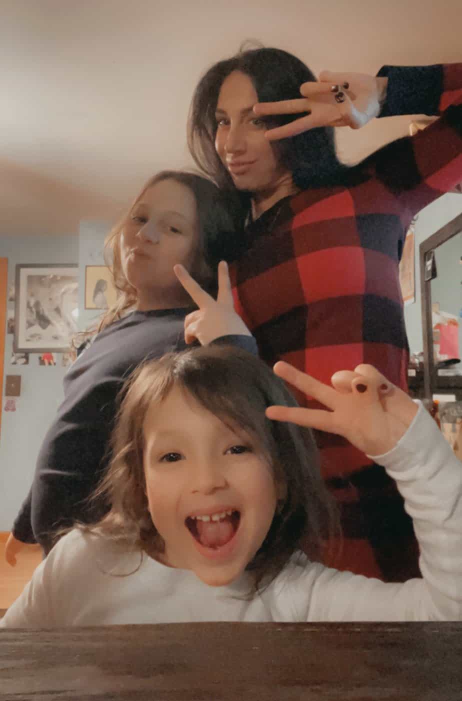 alison b and two daughters smiling with peace signs 