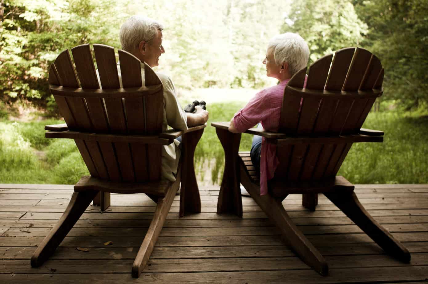 senior couple sitting on chairs on deck embracing slow living