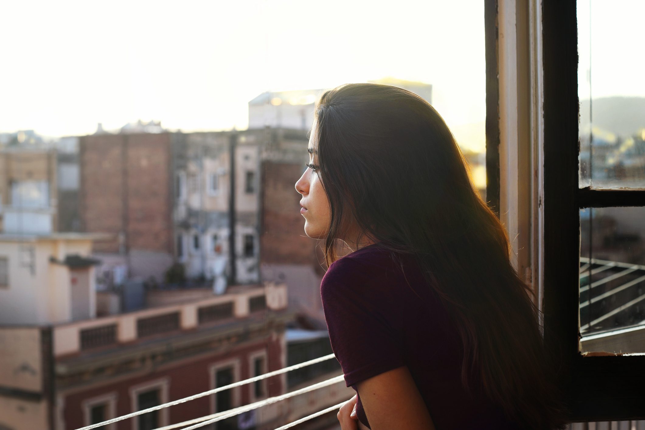 girl looking out balcony while experiencing drug comedown