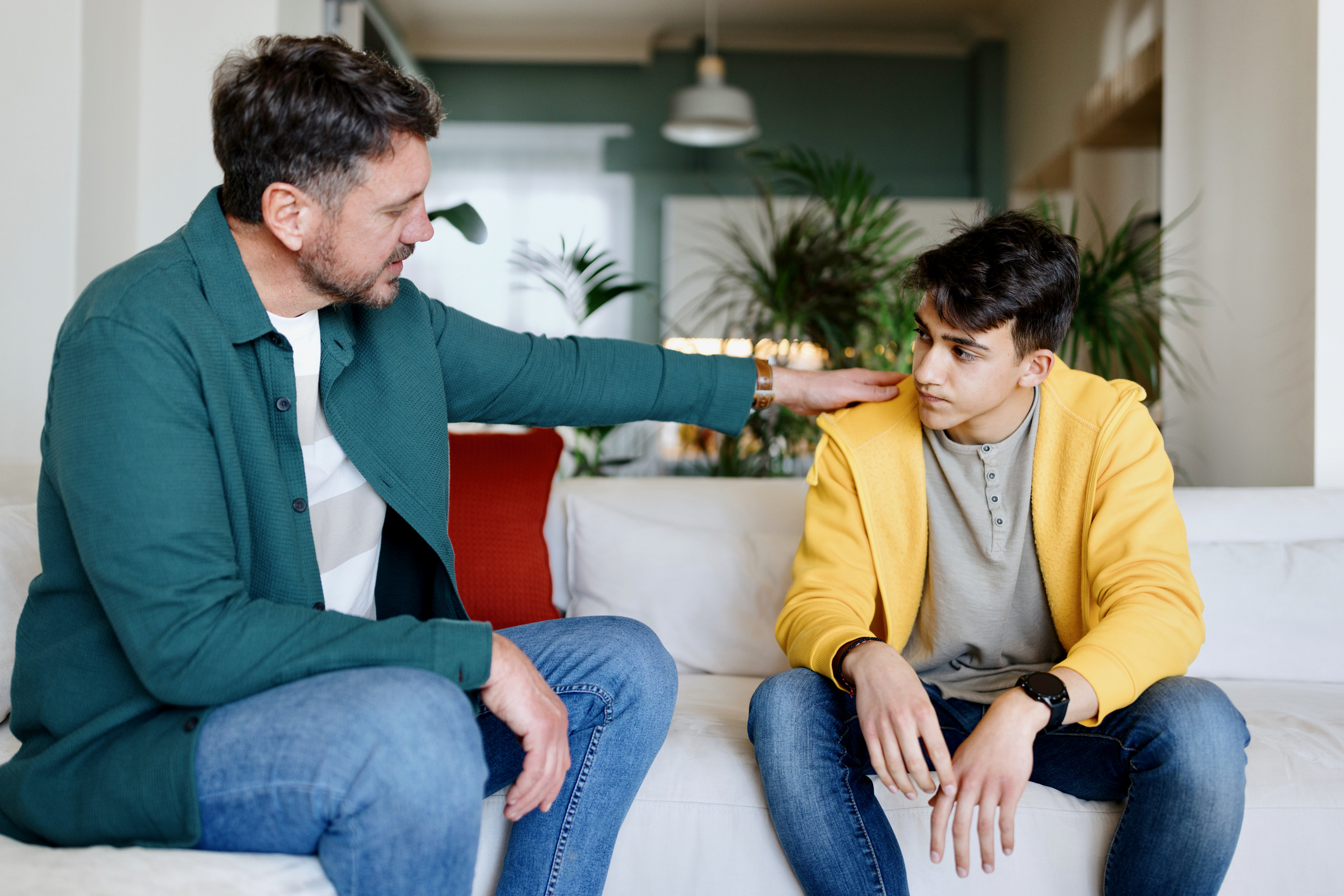 father putting arm on child's shoulder supporting child struggling with trauma