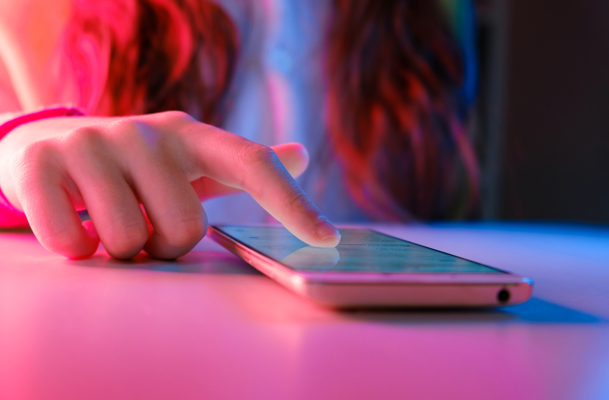 close up of teen girl scrolling on phone to learn about pink cocaine