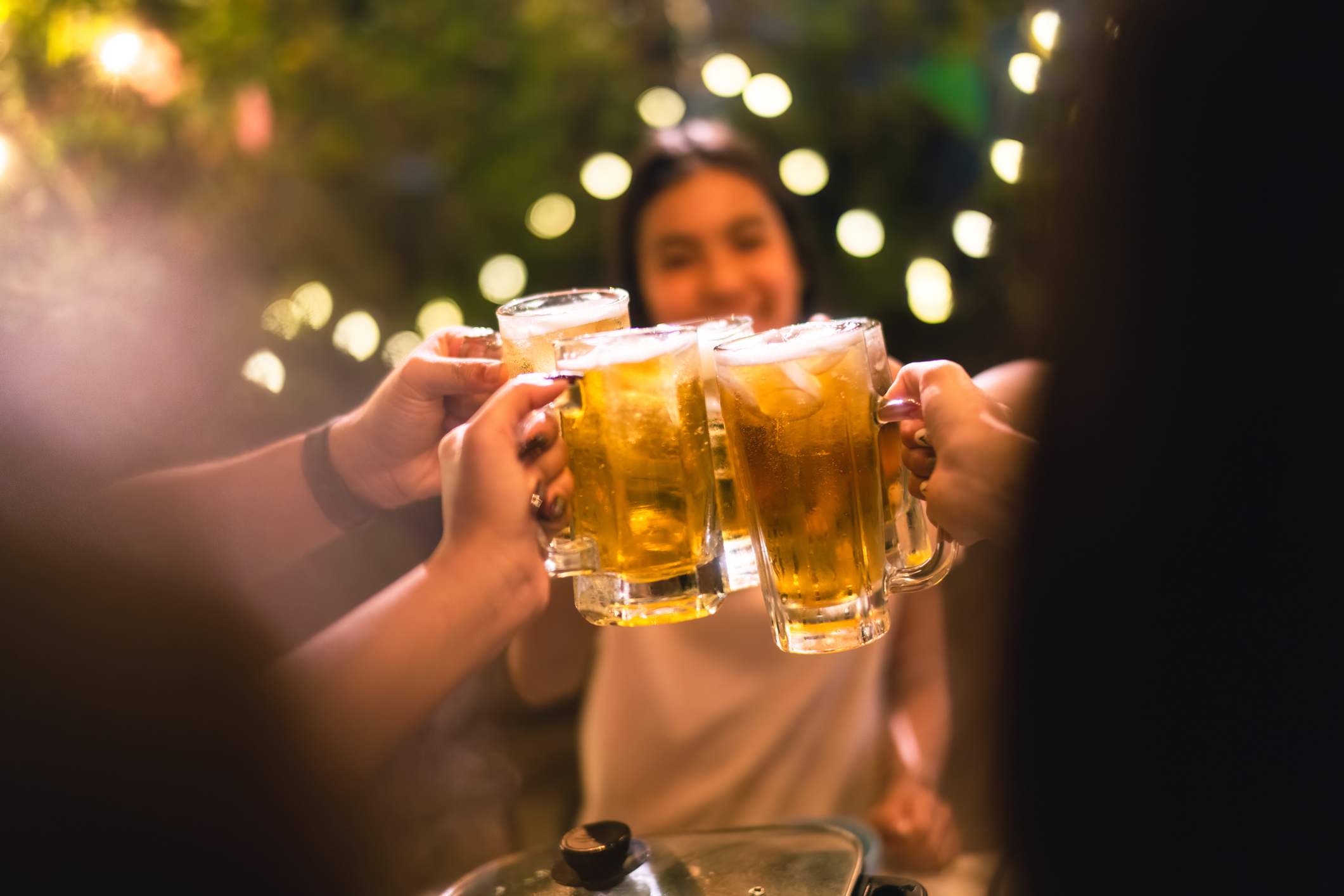 young people engaging in high-intensity drinking with beers in backyard