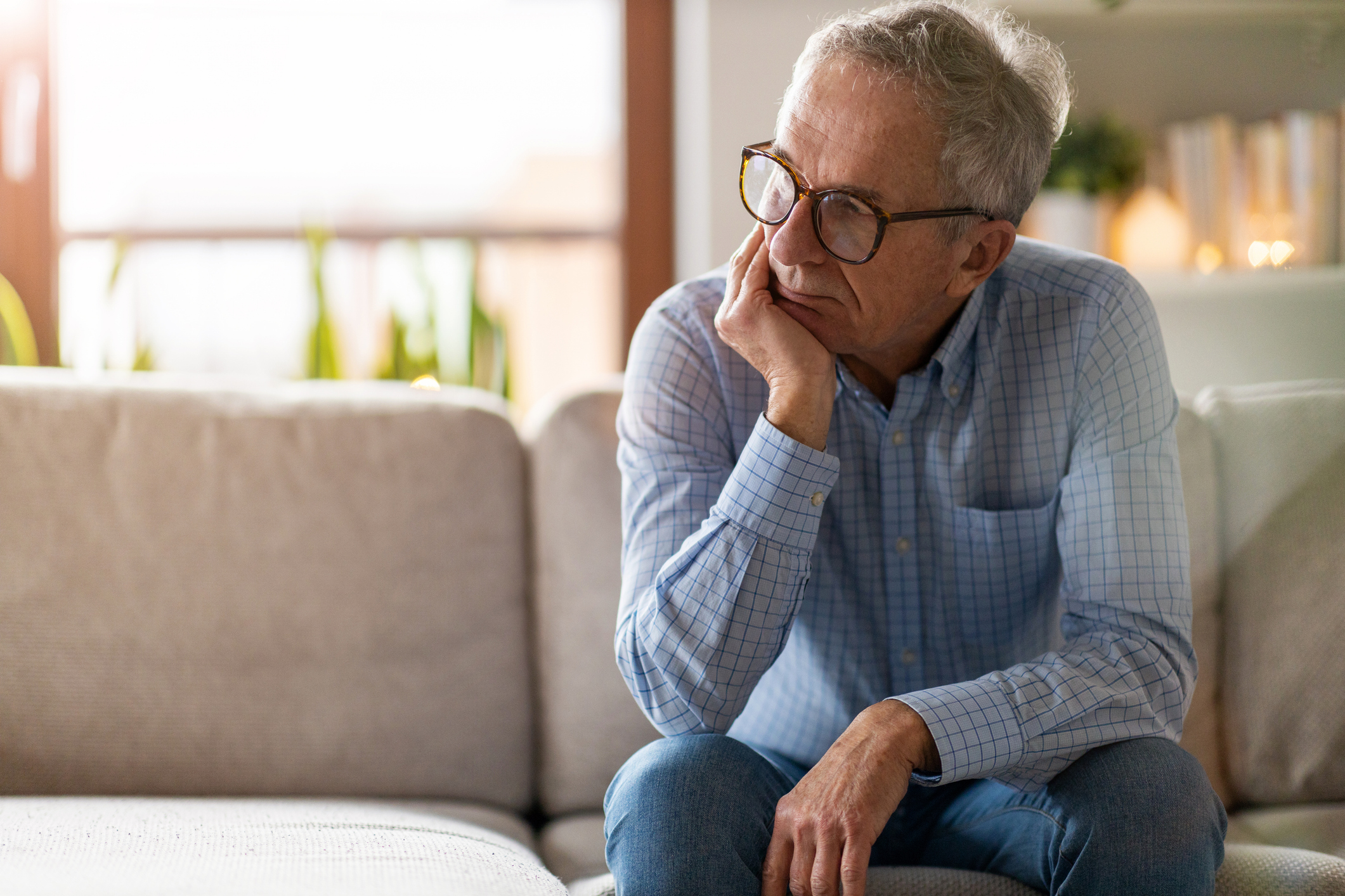 old man dealing with stigma of addiction puts hand on chin