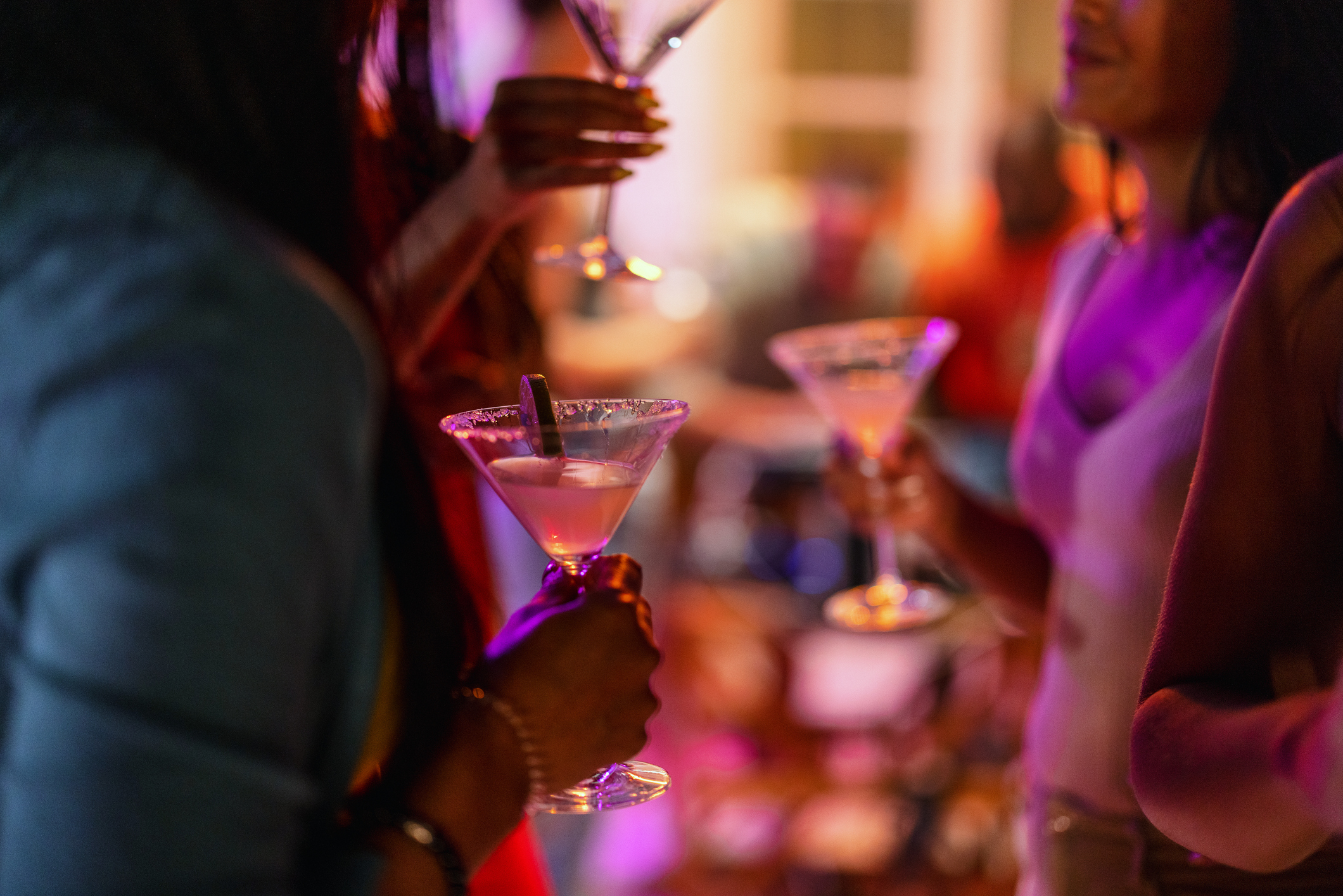 close up of group of friends holding martini glasses