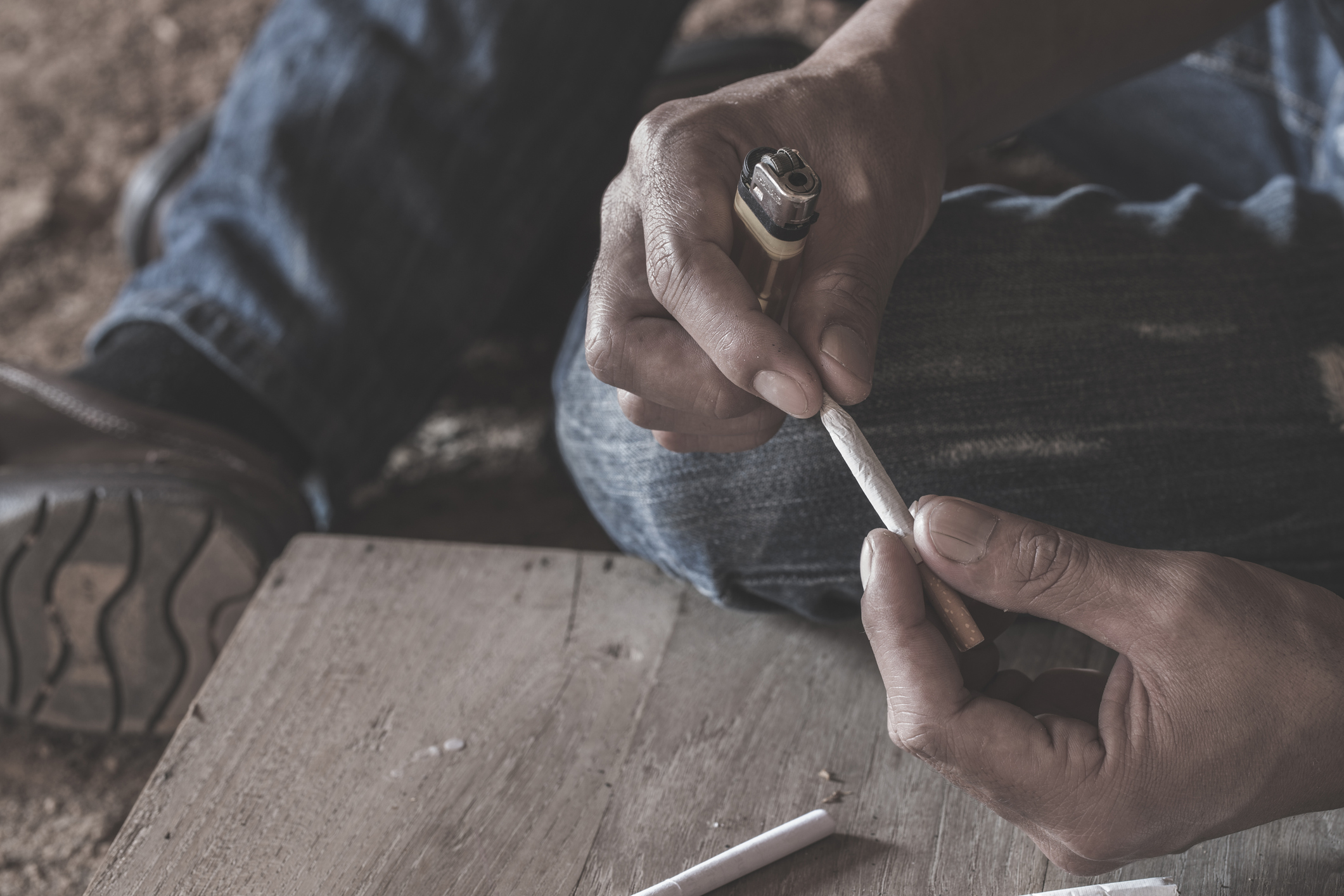 person holding a k2 spice blunt with lighter